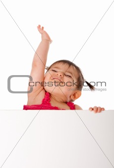 Happy baby holding white board and reaching up