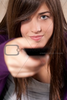 Young woman with remote control sitting on sofa close-up