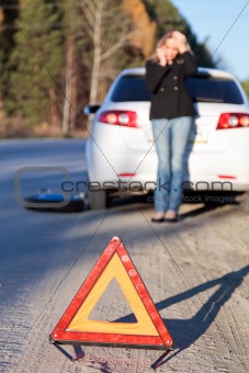 woman by her damaged car calling for help 