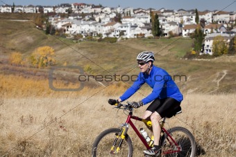 Man mountain biking in park near residential area