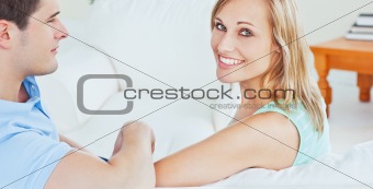 smiling young couple sitting on a sofa