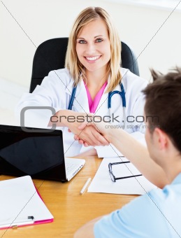 Smiling doctor shaking the hand of her patient 