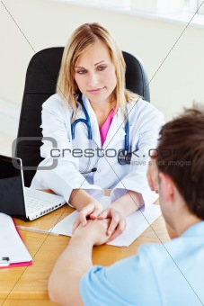 Attractive female doctor hanging the hand of her male patient 