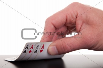 man's hand revealing four aces, isolated on white background, studio shot