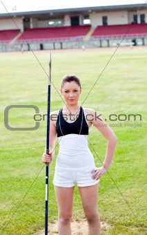 confident athletic woman ready to throw a javelin standing in a 