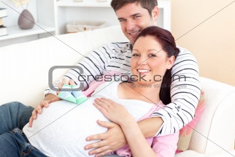 Portrait of a pregnant woman holding baby shoes
