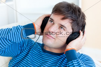 attractive young man listening music sitting in the living-room