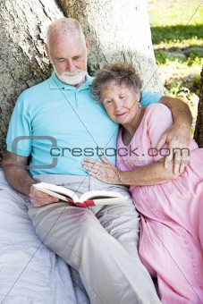 Senior Couple Reading Together Outdoors