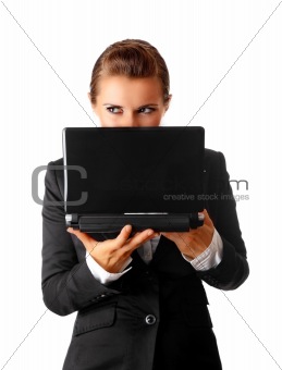 sly modern business woman suspicious looks out from laptop
