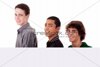 three young, of different colors man holding a white board, looking to camera, isolated on a white background