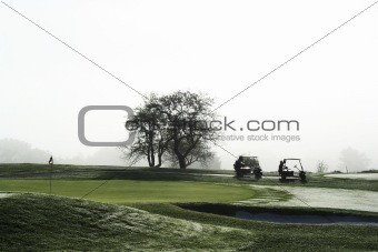 Golf carts waiting on green