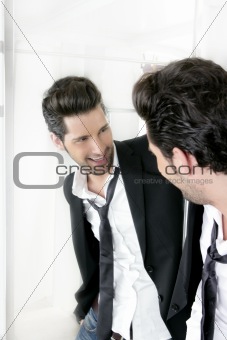 Handsome narcissistic young man looking in a mirror