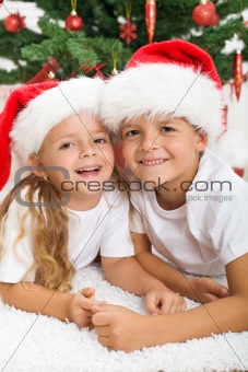 Happy kids in front of christmas tree