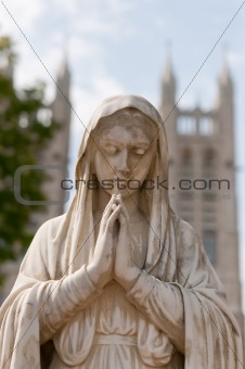 Praying Mary Statue in front of an old Church