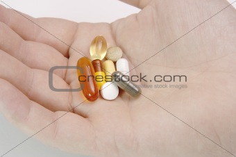Hand full of pills and vitamins