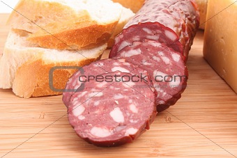 Sausage and bread on wooden surface