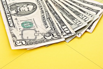 Few dollar banknotes on yellow background