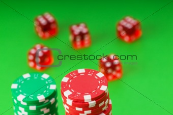 Casino chips and cards against green background