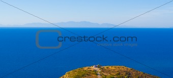 Cape, a lone house, the sea and the mountains in the distance. Rhodos. Greece
