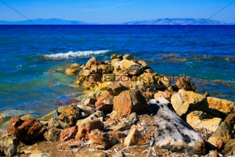 Stones on the Aegean coast and the mountains far away