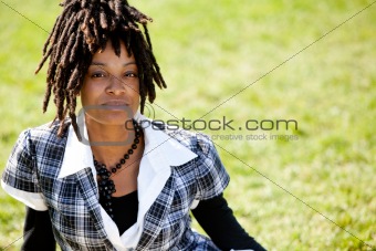 Attractive Young Woman Sitting in a Park