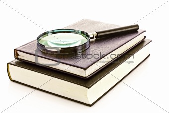 Hard cover book and magnifier isolated on white