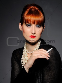 Beautiful retro woman with red lips holding cigarette and smokin