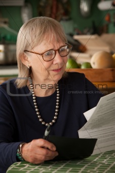Senior woman with many bills