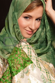 Young Arab woman with veil close-up portrait on dark background
