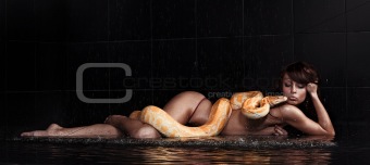 Beautiful woman lying with Python in water