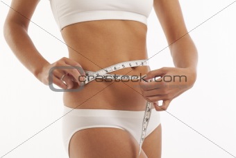 Young woman in underwear with measuring tape