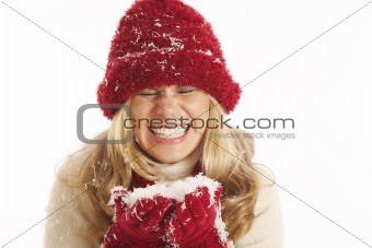Portrait of young woman with red hat and gloves holding snow