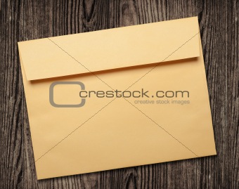 Golden envelope on wooden table.