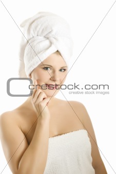 beautiful young woman in bath towel touching her skin