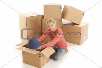 Young woman unpacking cardboard boxes