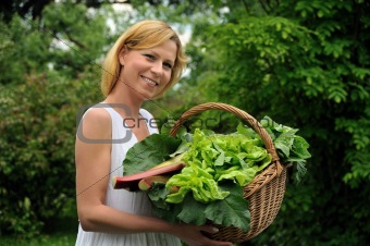 Young woman holding basket with vegetable