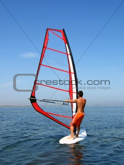 Windsurfer on waves of a gulf in the afternoon
