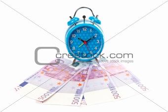 Alarm clock over a fan of money