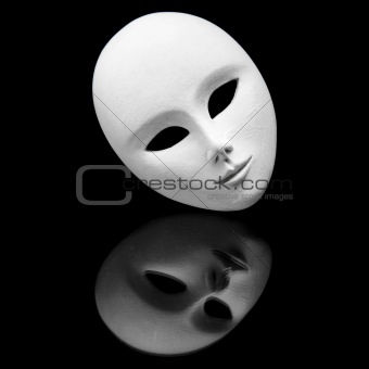 white impassive venetiain mask and its reflection in black mirror