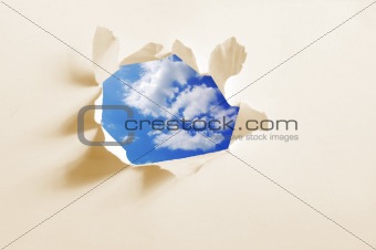cloudy sky behind paper hole
