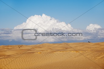 A lonely figure of a man and a motorbike in the desert
