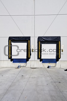Two freight loading doors with a set of green and red light to a