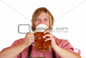 Happy Bavarian man drinks out of oktoberfest beer stein