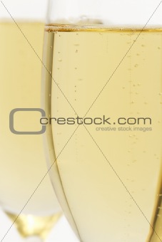 glass with champagne closeup in front of other