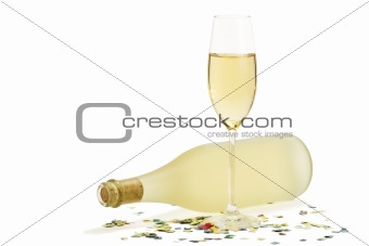 glass of champagne in front of prosecco bottle with confetti