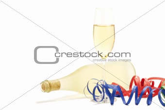 glass with champagne with streamer in front of a prosecco bottle