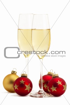 two glasses with champagne with one golden and three red christmas balls