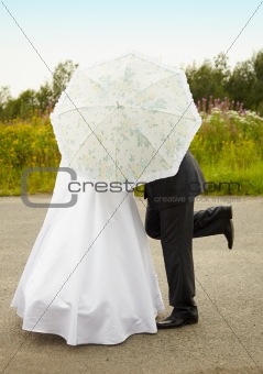 Couple kissing behind an umbrella