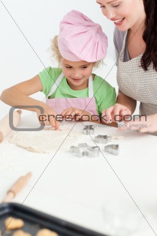 Cute daughter and her beautiful mother making cookies using baki