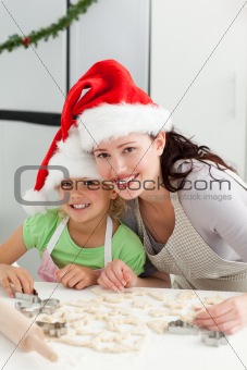 Beautiful mother and daughter cooking Christmas biscuits